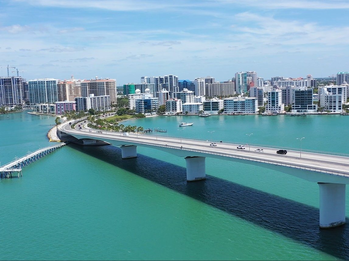 Looking back at the downtown Sarasota skyline from the middle of the John Ringling Causeway, a fishing pier below on Sarasota Bay