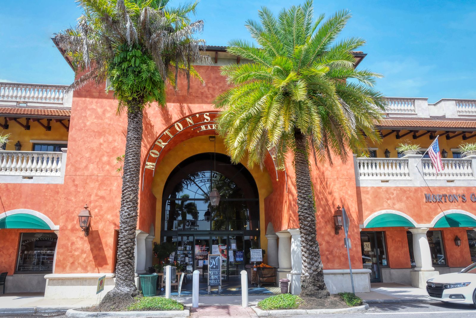 Palm-framed arched entrance to Morton's Gourmet Market in Southside Village, Sarasota